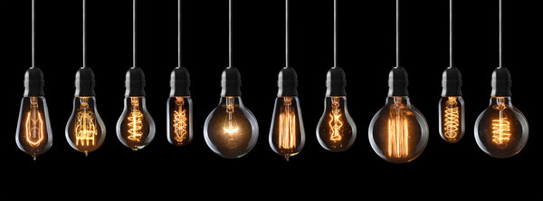 Set of vintage glowing light bulbs on black background