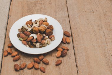 Resmin merkezinde ahşap arka planda çeşitli fındıklar var, seçici odak.