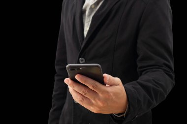 Siyah takım elbiseli bir işadamının beyaz bir arka planda elinde akıllı bir telefon olan bir iş adamının sol görüşünü yakından izle..