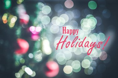 Noel ağaçlarının, süslerin ve bokeh 'in bulanık arkaplanındaki mutlu bayramlar tabelası.