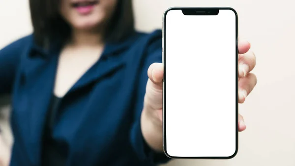 Beyaz bir kadının sol elinde siyah bir cep telefonu ya da cep telefonu ve beyaz ekran görüntüsü izole edilmiş ya da kesilmiş beyaz bir arka planda..