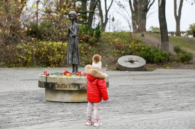1932-33 yılları arasında açlıktan ölen Holodomor kurbanlarının anıtının yanındaki kız. Kyiv, Ukrayna. Yüksek kalite fotoğraf