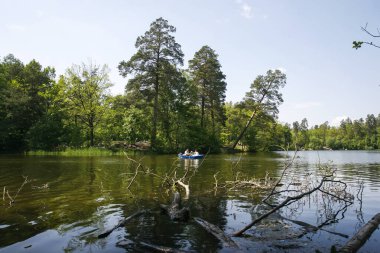 People float by boat on the lake in the famous Pushcha Vodytsya park in Kyiv, Ukraine. May 2011. High quality photo