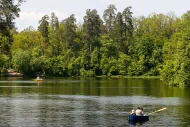 People float by boat on the lake in the famous Pushcha Vodytsya park in Kyiv, Ukraine. May 2011. High quality photo