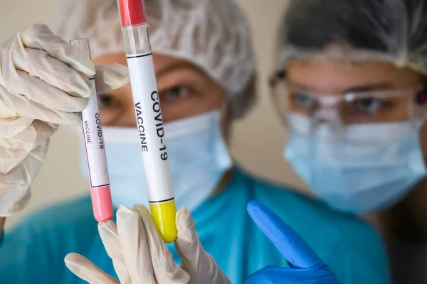 Védőruhás Arcmaszkos Emberek Koronavírus Elleni Vakcina Mintáival Ellátott Kémcsöveket Vizsgálják — Stock Fotó