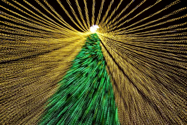 Conceptual photo of a decorated Christmas tree among the festive illumination. Long exposure. Selective focus. — Stock Photo, Image