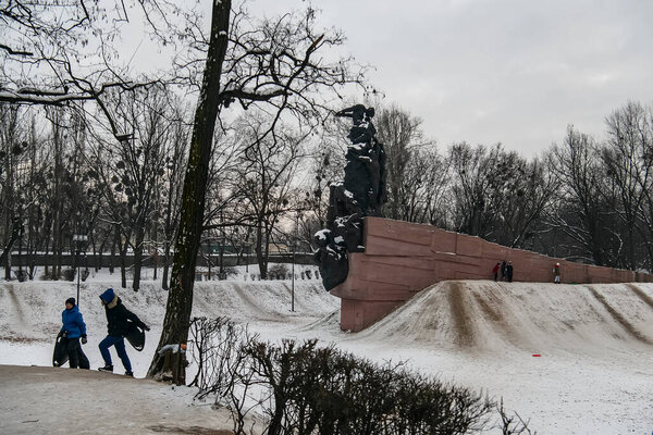 Дети спускаются по горке на санях возле Мемориала жертвам нацизма в Бабьем Яре в Киеве, Украина. 20 января 2021 года 