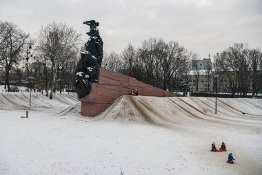 Ukrayna, Kyiv 'deki Babyn Yar' daki Nazizm kurbanlarının anısına. Çocuklar Memorial yakınlarındaki kızaklara binip kayıyorlar..