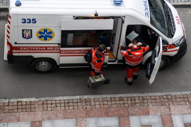 Ukrayna 'nın başkenti Kyiv' de ambulans arabasının yanında bir ambulans doktoru ekibi. Ocak 2021 Ukraynaca yazı - Ambulans.