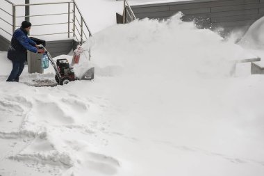 Ukrayna 'nın başkenti Kyiv' de 8 Şubat 2021 'de kar yağışı sırasında bir kar makinesiyle kar temizleyen şehir işçisi. Yüksek kalite fotoğraf