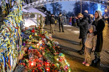 20 Şubat 2021 'de Kyiv' deki Bağımsızlık Meydanı 'nda 2014 yılında hükümet karşıtı protestolarda öldürülen aktivistlerin portrelerinin yanında çiçekler ve mumlar. Yüksek kalite fotoğraf