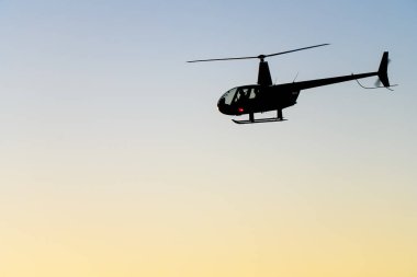 Akşam gökyüzünün arka planında bir helikopterin silueti. - Evet. Yüksek kalite fotoğraf