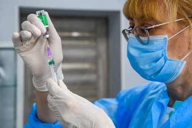 Ukrayna 'nın başkenti Kyiv' deki bir hastanedeki bir şişeden bir doz AstraZeneca Covishield aşısı alıyor.