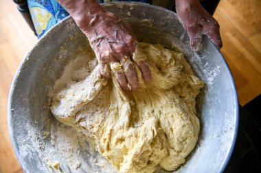 Evde pişirmek için büyük bir porsiyon hamur yapan yaşlı bir kadının elleri. Yüksek kalite fotoğraf