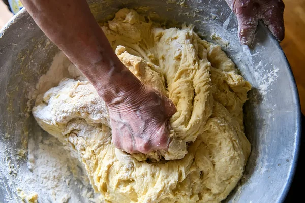 Руки літньої жінки, яка робить велику порцію тіста для випічки вдома — стокове фото