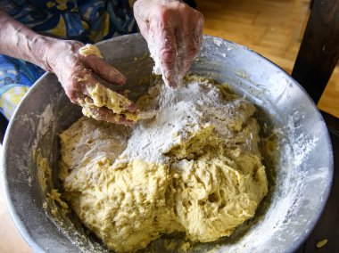 Evde pişirmek için büyük bir porsiyon hamur yapan yaşlı bir kadının elleri. Yüksek kalite fotoğraf