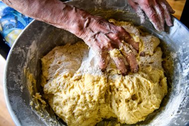 Evde pişirmek için büyük bir porsiyon hamur yapan yaşlı bir kadının elleri. Yüksek kalite fotoğraf