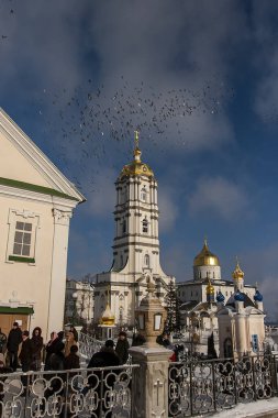 Çan kulesi, Trinity Katedrali ve Ukrayna 'nın Pochayiv Lavra, Pochayiv manastırı üzerinde uçan güvercin sürüsü. Ocak 2009