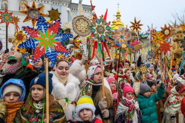 Ukraynalılar 25 Aralık 2025 'te Ukrayna' nın başkenti Kyiv 'de Noel şarkıları söyler ve Beytüllahim' in süslü yıldızlarını taşırlar. Yüksek kalite fotoğraf