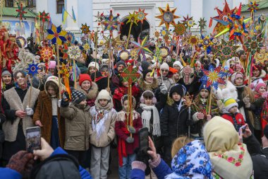 Ukraynalılar 25 Aralık 2025 'te Ukrayna' nın başkenti Kyiv 'de Noel şarkıları söyler ve Beytüllahim' in süslü yıldızlarını taşırlar. Yüksek kalite fotoğraf