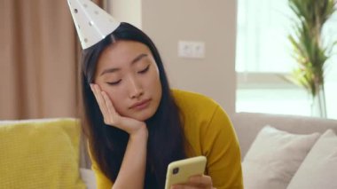 Mutlu olmayan Çinli kadın doğum günü için evde tek başına kalıyor. Şenlik şapkasını çıkarıyor. Akıllı telefondan hiç mesaj gelmiyor. Üzücü tatiller. Sosyal uzaklık. İzolasyon kavramı.