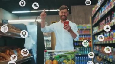 Çevrimiçi akıllı telefon uygulaması kullanan beyaz sakallı bir adam sosyal medyayı kullanarak süpermarketten alışveriş yaparken internet popülaritesini artırmayı seviyor..