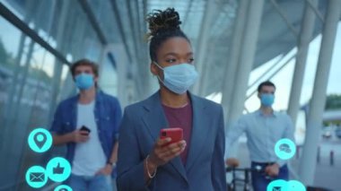 Maskeli İş Adamları Yürüyüşü. Akıllı Telefon Kullanıcı Arayüzü ile Afrikalı Amerikalı Moda Çevrimiçi Etkilenen Kadın Bolca Bulut Bildirimi Alma Teknolojisi. Karantina.