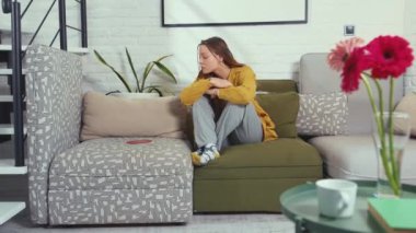 Oturma odasındaki kanepede oturan frikan örgülü sıkıcı kız. Genç, çekici, mutlu kız telefonda sosyal ağlarda beğeni ve yorumlar hakkında uyarılar okuyor. Blog yazarları karantinada