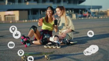 Paten kayarak yerde oturan kadınlar telefonla konuşuyor. Sokakta selfie çekiyorlar. Vlog tutucu sosyal medya, uygulama simgeleri beyaz arayüzlü yüksek sesle canlandırma. Yavaş çekim
