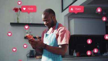 Afro-Amerikalı çekici bir adam yemek pişirirken internette geziniyor. Şok oldum. Kullanıcı arayüzü - beğeni, takipçi, sosyal medya yorumları ile Vlogger etkili animasyon. Yavaş çekim