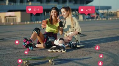 Patenlerle yerde oturan kadınlar telefonda konuşuyor. Selfie çekiyorlar. Tamam. Kullanıcı arayüzü - beğeni, takipçi, sosyal medya yorumları ile Vlog tutucu canlandırması.