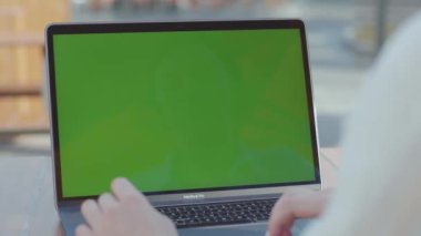 NEW YORK - 5 Eylül 2020: Gümüş dizüstü bilgisayarın klavyesinde güzel manikürlü bir kadının elinin yakın çekimi. Yönetici ahşap masada oturuyor, portatif kişisel bilgisayarla çalışıyor.