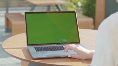 NEW YORK - 5 Eylül 2020: Gümüş dizüstü bilgisayarın klavyesinde güzel manikürlü bir kadının elinin yakın çekimi. Yönetici ahşap masada oturuyor, portatif kişisel bilgisayarla çalışıyor.