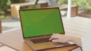 NEW YORK - 5 Eylül 2020: Gümüş dizüstü bilgisayarın klavyesinde güzel manikürlü bir kadının elinin yakın çekimi. Yönetici ahşap masada oturuyor, portatif kişisel bilgisayarla çalışıyor.