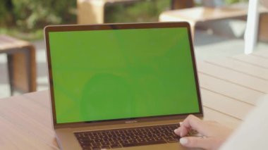 NEW YORK - 5 Eylül 2020: Tanınmayan kişi yeni dizüstü bilgisayar modeliyle masada oturuyor, internette geziniyor, haberleri okuyor, sosyal ağlarda sörf yapıyor. Kafede taşınabilir bilgisayarda el yazısı yazan bir kadın. Gündüz