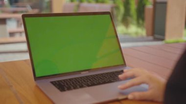 NEW YORK - 5 Eylül 2020: Manikürlü bir kadının elinin yakın plan görüntüleri dizüstü bilgisayarın klavyesinde yeşil ekranlı siyah takım elbise giyiyor. Blog yazarı kafein masasında oturuyor, internette sörf yapıyor, haberleri okuyor.