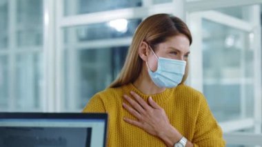 Koronavirüs hastası, maske takan, sağlıksız, beyaz, genç, yetişkin bir iş kadını doktor randevusuna gidiyor. Modern hastanelerde tedavi görüyor..