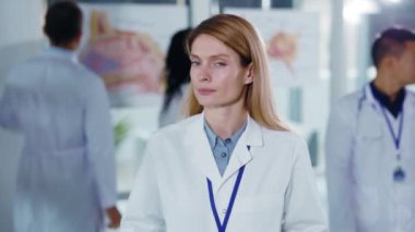 Çekici sarışın, beyaz kadın pratisyen doktorun, kameraya gülümseyen neşeli doktor portresi. Başarılı insanlarız. Hemşire yardımcısı. Sağlık Hizmetleri Hastanesi.