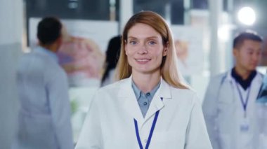 Özel hastanede çalışan, boynunda steteskop olan, kameraya gülümseyen, profesyonel kadın doktor portresi..