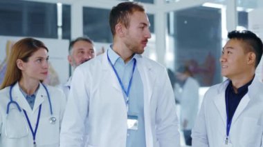 Bir grup Kafkasyalı ve çok ırklı uzman doktor hastane ofisinde görüşmeler yaparak alkışlıyorlar. Tıbbi personel. Takım çalışması..