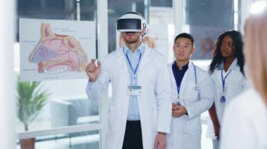 Kafkasyalı profesyonel doktor doktor. Yeni sunum gerçekliği kulaklığı takıyor. Tıbbi personele sunuyor ve çalışmalarını onaylıyor. Gelecekteki teknolojiler.
