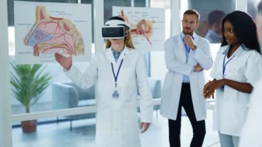 VR kulaklık takan profesyonel bir kadın doktor hastanede koronavirüsle ilgili sanal 3 boyutlu projemizi sunuyor. Modern teknolojiler.