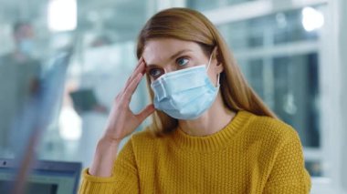 Koronavirüs enfeksiyonu teşhisini duyan, maske takmış, hasta, genç ve sağlıksız bir kadın koltukta kendini kötü hissediyor. Tıbbi bir randevu. Doktor ziyareti. Karantina.