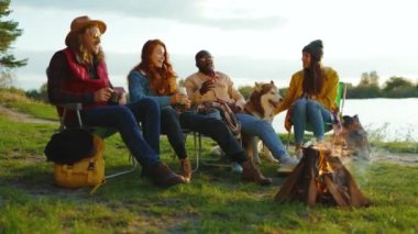 Göl kenarında şık arkadaşlar doğada kamp ateşinin yanında oturuyorlar. Gençler oyunlar hakkında konuşurlar, köpeklerin gülümsemesiyle mutlu olurlar. Tatil turizmi macerası. Yavaş çekim