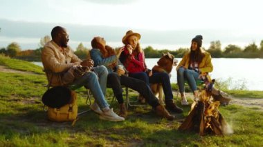 Sakin ol, kamp ateşinin yanında oturan bir grup arkadaş. Gençler oyunlar hakkında konuşurlar, köpeklerin gülümsemesiyle mutlu olurlar. Tatil turizmi macerası. Yavaş çekim