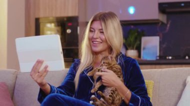 Çekici, komik, sarışın, beyaz kız Bengal kedisini okşuyor. Güzel bir akşam geçiriyor, ailesiyle video kaset konferansında eğleniyor ve evde yalnız kalıyor..