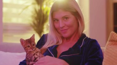 Şahane güzel beyaz kadın portresi kameraya neşeyle gülümsüyor sevimli bir kedi yavrusu tutuyor. İnanılmaz kediler. Aile fotoğrafı..