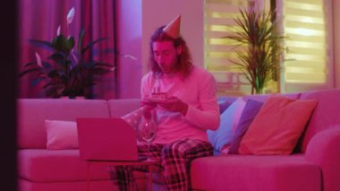 Uzun saçlı genç hippi kız arkadaşını kutluyor. Doğum gününü kutluyor. Laptop bilgisayar video konferansında iyi ki doğdun diyor..