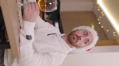 Yeni yılda masada tek başına oturup içki içen üzgün bir adamı yakından çek. Noel arifesi. Tatilde dekore edilmiş evde kendini yalnız hisseden mutsuz bir adam. Yalnızlık kutluyor. Yavaş çekim