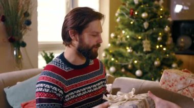 Mutlu, sevecen aile çifti genç adam ve kadın kış tatillerini birbirlerine sarılmak için güzel hediyeler vererek geçiriyorlar. Duygular konsepti.